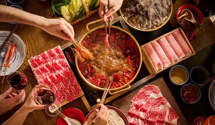 A communal hot pot with various ingredients